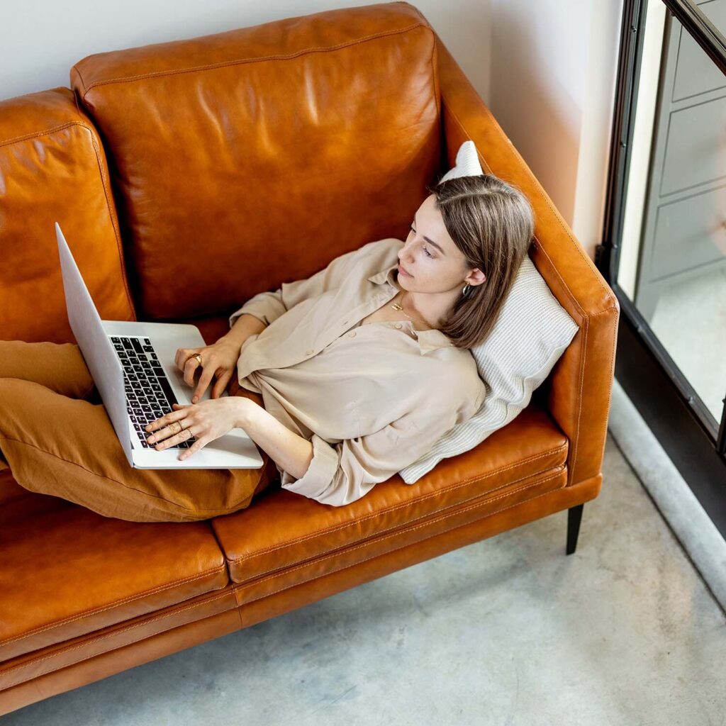 woman working on laptop and lying on sofa 34pdydr 2.jpg